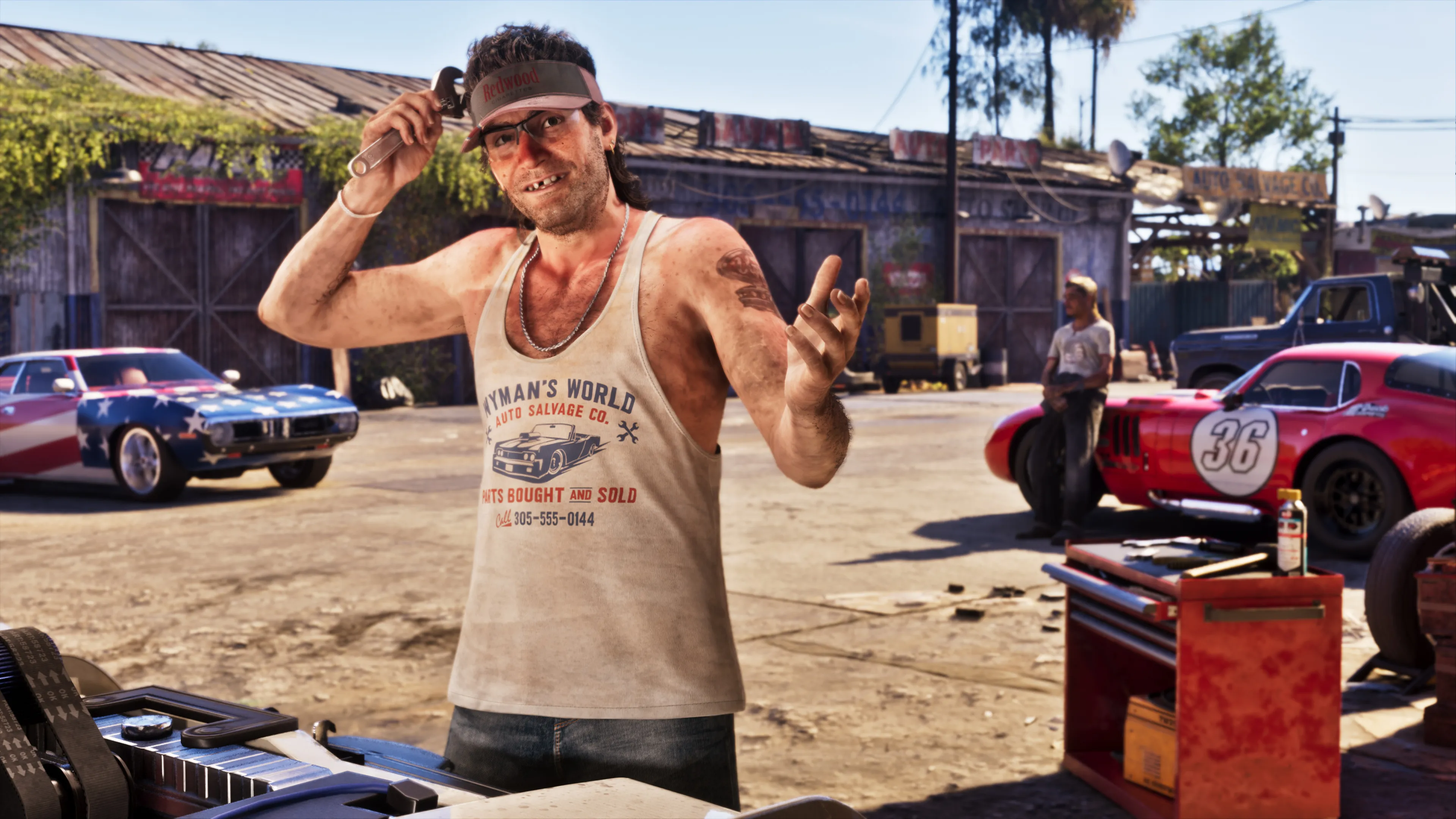Wyman in a Wyman's World Auto Salvage Co. tank top holding a wrench in his salvage yard, with a stars-and-stripes muscle car and a red number 36 race car behind him, from the GTA 6 Ultimate Edition's Classic Car Collection. Official Rockstar Games artwork.