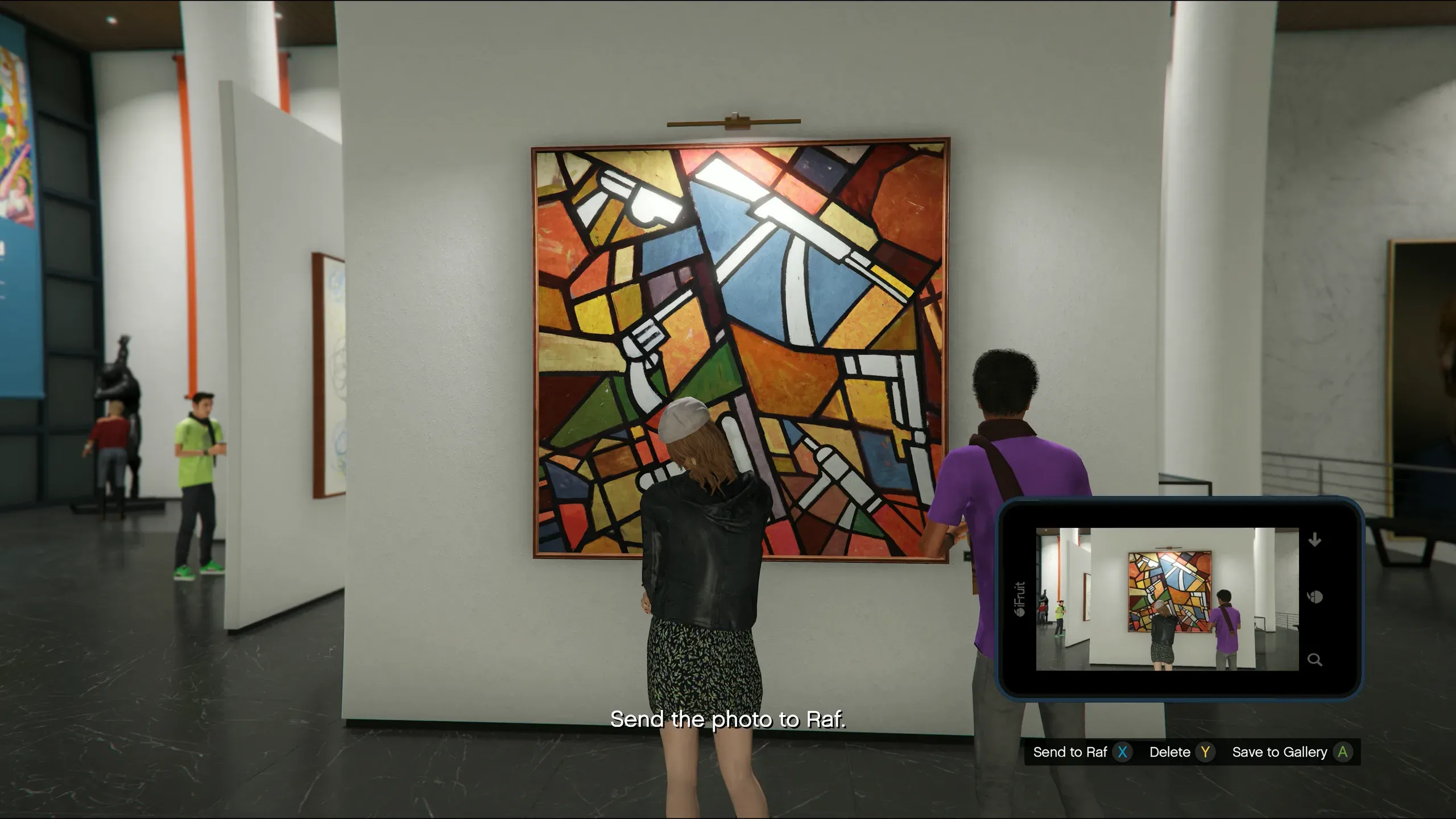 Scoping out the Kortz Center in GTA Online: a player raises an iFruit phone to photograph a large cubist gallery painting of stylised white pistols on colourful geometric panels, with the on-screen prompt to send the photo to Raf